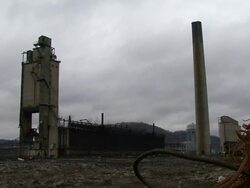 WS Tall smokestack at  power plant is demolished using explosives   and explodes in  cloud of black dust / Weirton, West Virginia, USA Stock Footage