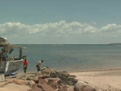 Pearling boat and crew on tropical beach, Australia Stock Footage