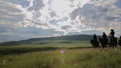 Female ranchers horseback riding in sunny remote rural field Stock Footage