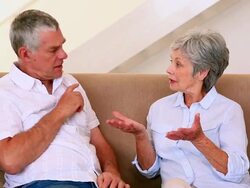 Senior couple sitting on couch having an argument Stock Footage