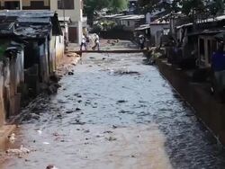 MS Shot of local people and local life with houses near Sewer / Freetown, Sierra Leone Stock Footage