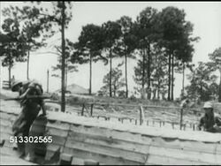 1942: FORT JACKSON REVIEW: British Prime Minister Winston Churchill walking w/ Brigadier General William C. Lee, VS US Army infantry soldiers in full uniform moving through training course, over short obstacles, hand-over-hand above water hazard. Instructional Video