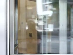 MS Young man walking throug turnstile door in urban building and talking on cell phone / Minneapolis, Minnesota, United States Stock Footage