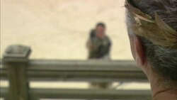 An archer shows a spectator the remains of an ostrich killed during a reenactment of a Roman blood spectacle. Stock Footage