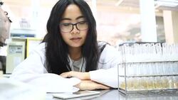 Young Asian women scientist wake up with alarm clock in laboratory Stock Footage