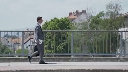 Yuppie walking across the bridge in city Stock Footage