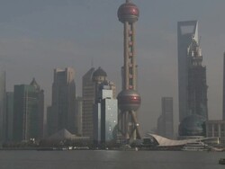 Ships and barges sail through downtown Shanghai past the famous skyline of Pudong, China Stock Footage