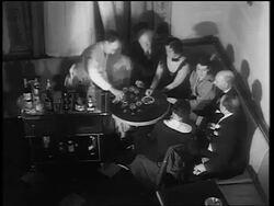B/W 1933 high angle male bartender pouring drinks for group sitting at table / end of Prohibition Stock Footage