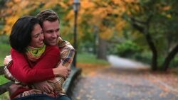 New York couple in love hold each other close on park-bench in the heart of Central Park in fall (dolly-shot) Stock Footage
