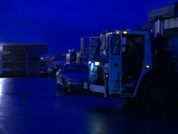 A sanitation worker waves to a trucker in a garbage truck lot in New York City. Stock Footage