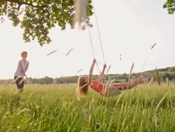 SLO MO Woman and girl playing on tree swing Stock Footage