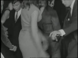 A musician plays the saxophone as young couples perform the twist. News Clip