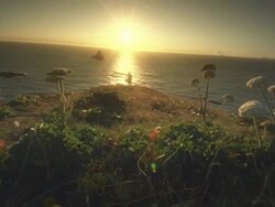 MS SLO MO POV Woman with cape in wind by Ocean at sunset / Cape Blanco, Oregon, United States Stock Footage