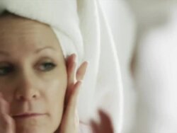 CU Woman with towel turban looking at her face in bathroom mirror / Cedar Hills, Utah, USA Stock Footage