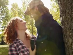 Smiling couple taking self portrait with smart phone in park Stock Footage