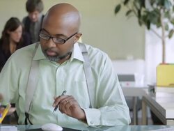 CU Businessman talking on mobile phone while employees working in background / New York, USA Stock Footage