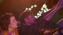 Young man takes smartphone photo of band at outdoor music festival and shares with friends Stock Footage