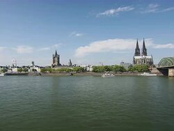 WS Shot of Cologne Cathedral at Old City and boat moving under train bridge with Blue sky / Cologne, North Rhine-Westphalia, Germany Stock Footage