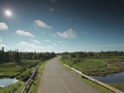 Country road with a stream and a green land beside  Stock Footage