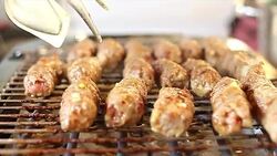 Traditional Eastern European barbecue food kebab-cevapcici Stock Footage