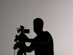 Videographer Cameraman Shooting, Focus and Panning; Silhouette Stock Footage