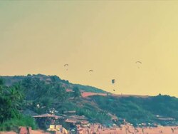 T/L paragliders over beach, Anjuna, Goa Stock Footage
