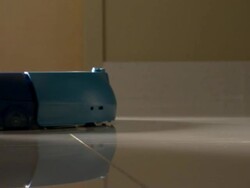 Medium Close Up pan-right - A small robotic vacuum cleaner moves along a tile floor.   Stock Footage