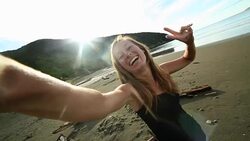 Cheerful young woman takes a selfie portrait on the beach Stock Footage