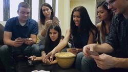 Young adult women playing cards with boyfriends, mother and sister Stock Footage