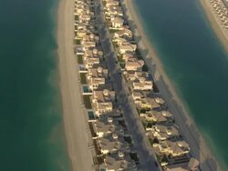 WS AERIAL View of Plane flying above large band of beach houses with water all around showing parallelism between constructions / Dubai, United Arab Emirates Stock Footage