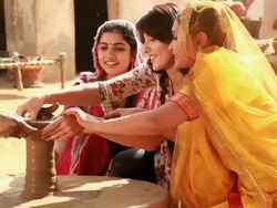 Three young women making pot with a potter on a pottery wheel, Haryana, India Stock Footage