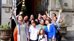 MS TD Daughter taking self portrait with smartphone of multigenerational family gathered in front of entrance of restaurant before party Stock Footage