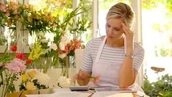 Stressed florist calculating business finances in flower shop Stock Footage