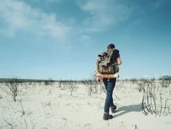 Backpacker walking through the desert Stock Footage