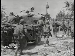 1943: TAKING MAKIN ATOLL: HA XWS Soldiers of 165th Infantry Regiment of Army 27th Division moving around lagoon w/ crashed Japanese seaplane. WS Soldiers walking by seaplane wreckage. WS soldiers walking up roadway. WS Wreckage of Japanese seaplane. Instructional Video