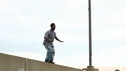 MS LA Man dancing along rooftop wall Stock Footage