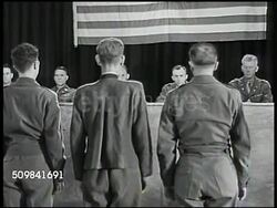 1945: MILITARY TRIBUNAL: VERDICT: VS German Nazi Franz Strasser & interpreter standing. (POV behind) MS Standing before U.S. Military Commission, finding Strasser guilty of all charges. MS Strasser (C) & two interpreters listening to sentence. Instructional Video