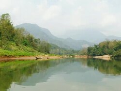 WS POV SLO MO Shot of green river with mountains and small wooden boats, canoes / Boat from Nong Khio to Muang Ngoi, Luang Prabang, Laos Stock Footage