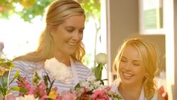 Florists talking and arranging flowers in flower shop Stock Footage