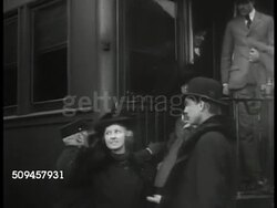 1936: U.S. TRAVELING THEATRE: WS Theatre troop getting off train, unloading luggage. MS People stepping off train. WS Man unloading large suitcase from freight. WS People standing by train. Instructional Video