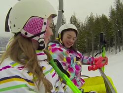 Two young girls riding chair lift at ski hill Stock Footage