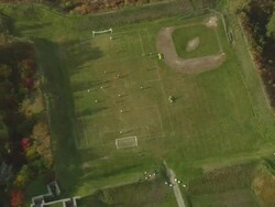 MS AERIAL DS ZO TS View of child playing football at Castine town / Maine, United States Stock Footage