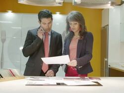 TS LA MS salesman and female client discussing  plans  in a kitchen showroom showing modern furniture Stock Footage