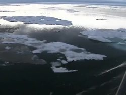 Icebreaker moving through melting ice floes News Clip