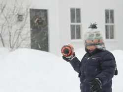 MS PAN Brothers playing with rugby ball during snowstorm  / Yarmouth, Maine, USA Stock Footage