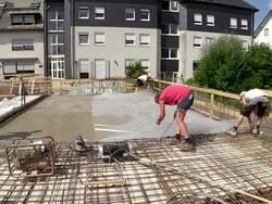 MS Shot of workmen working plastic overspread on floor at construction site / Hermeskeil, Rhineland Palatinate, Germany Stock Footage