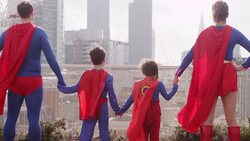 Superhero family holding hands on city rooftop Stock Footage