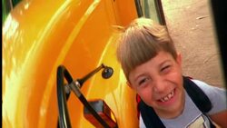 A boy's smiling face reflects in a school bus mirror. Stock Footage