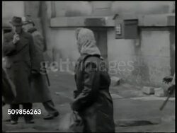 1946: GERMAN BLACK MARKET RAID:  Crowd of people outside, woman standing by two men, reaching into man's briefcase. German Police jumping out of truck, running toward people, pushing people onto truck, woman standing crying, truck filled w/ people. Instructional Video