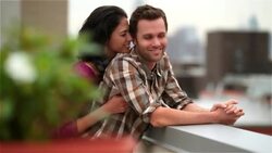 Hip young man on Brooklyn rooftop surprised by girlfriend with a kiss (dolly-shot) Stock Footage